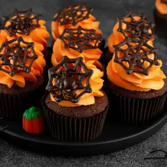 Przerażająco pyszne babeczki halloween z pomarańczowym kremem i czekoladowymi pajęczynkami. Idealne na straszne przyjęcie!