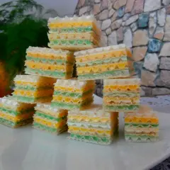 Kolorowe wafle z galaretką, ułożone w piramidkę na białym talerzu.
