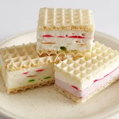Ptasie mleczko z galaretki w wafelkach. Kremowe nadzienie z kolorowymi kawałkami galaretki, przełożone chrupiącymi wafelkami.