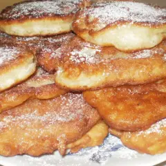 Góra puszystych racuchów bez drożdży, posypanych cukrem pudrem. Idealne na szybkie śniadanie lub deser.