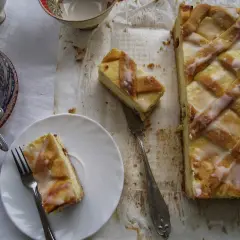Pyszny sernik krakowski z kratką z ciasta i lukrem, jeden kawałek na talerzyku, gotowy do degustacji.