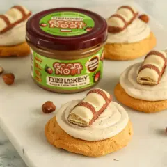 Pyszne ciasteczka inspirowane przepisem na crumbl cookies, z kremem i kawałkami Kinder Bueno. Słoik pasty z orzechów laskowych Good Now zachęca do eksperymentów.