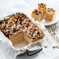 Pyszne, wielowarstwowe ciasto snickers z orzeszkami i polewą czekoladową, gotowe do podania.