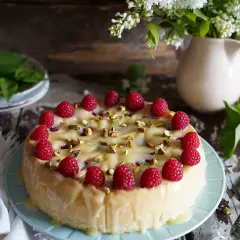 Wykwintny sernik z malinami i pistacjami, polany kremowym lukrem. Idealny na specjalne okazje.