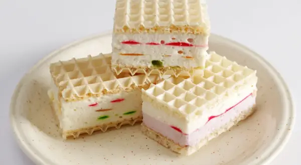 Ptasie mleczko z galaretki w wafelkach. Kremowe nadzienie z kolorowymi kawałkami galaretki, przełożone chrupiącymi wafelkami.