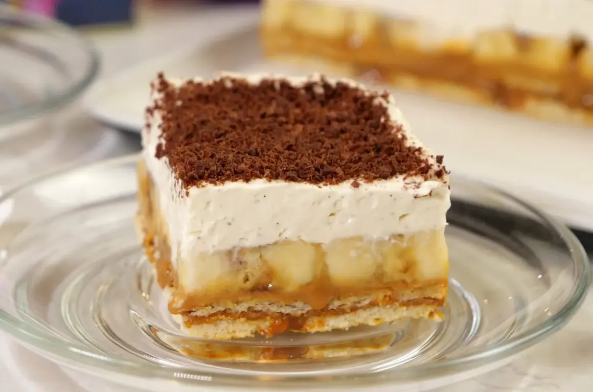 Pyszna tarta banoffee z warstwami banana, karmelu i bitej śmietany, posypana czekoladową posypką.