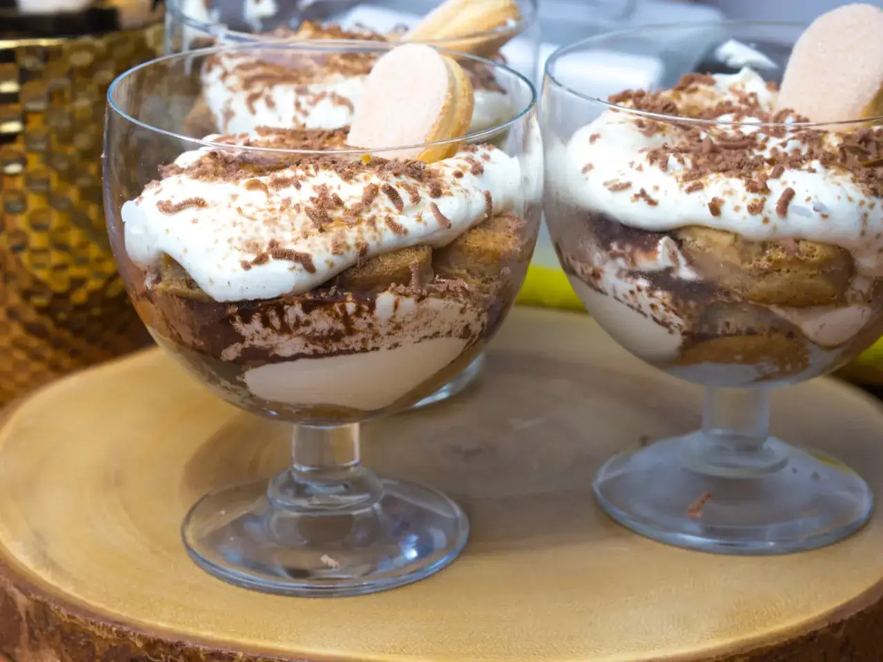 Pyszne tiramisu w pucharkach, udekorowane startą czekoladą i biszkoptami. Idealne na deser.