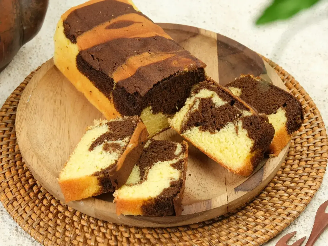 Pyszna babka marmurkowa, pokrojona na kawałki, prezentuje swoje czekoladowo-waniliowe wzory na drewnianej desce.