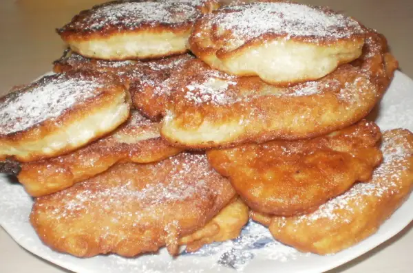 Góra puszystych racuchów bez drożdży, posypanych cukrem pudrem. Idealne na szybkie śniadanie lub deser.